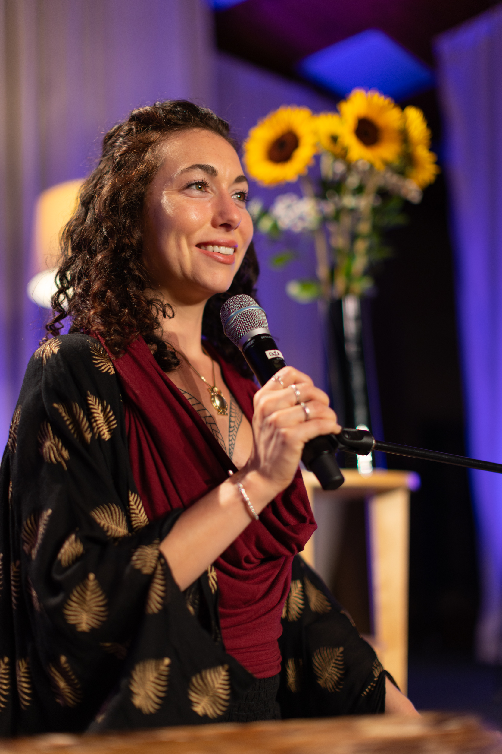 Eluña Noelle speaking into a microphone at Omega Institute