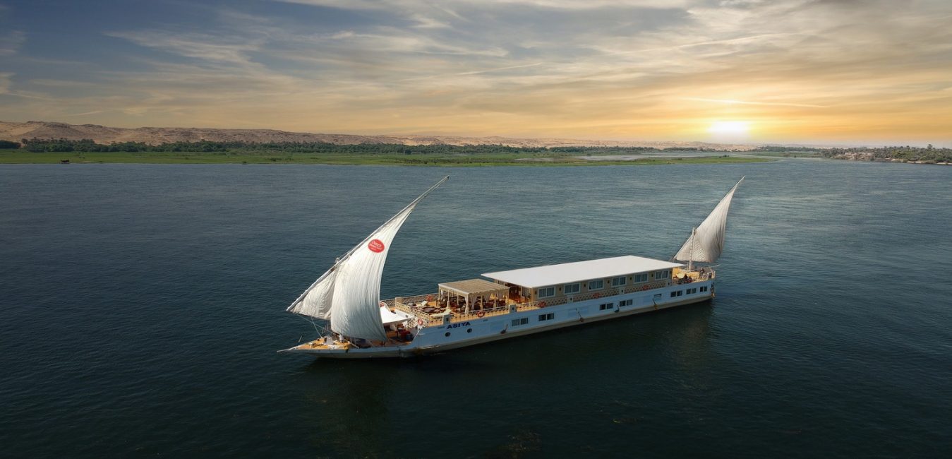 The private Dahabiya sailboat under full sail on the Nile at sunset